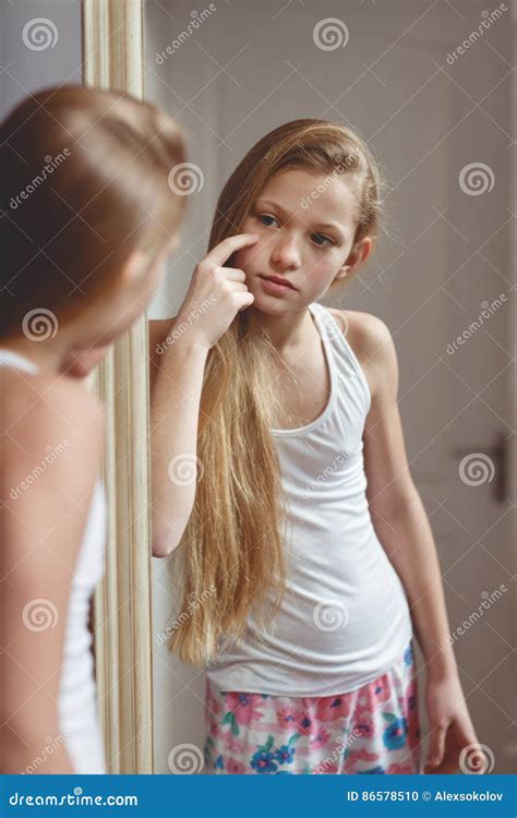 teens naked|An adolescent girl, posing naked leaning on a small table, in a .